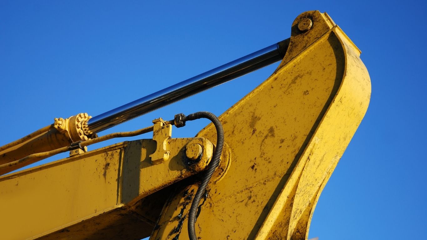 Excavator hydraulic cylinders and boom demonstrating how hydraulic pressure and flow support lifting and movement.